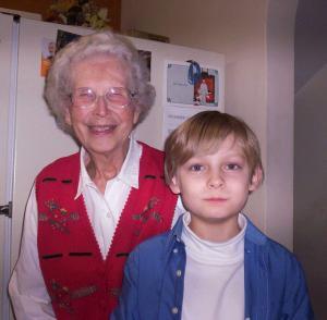 My grandmother standing with my son in front of a refrigerator.