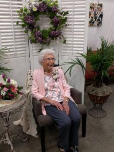 Virginia Tennant, sitting under a wreath.