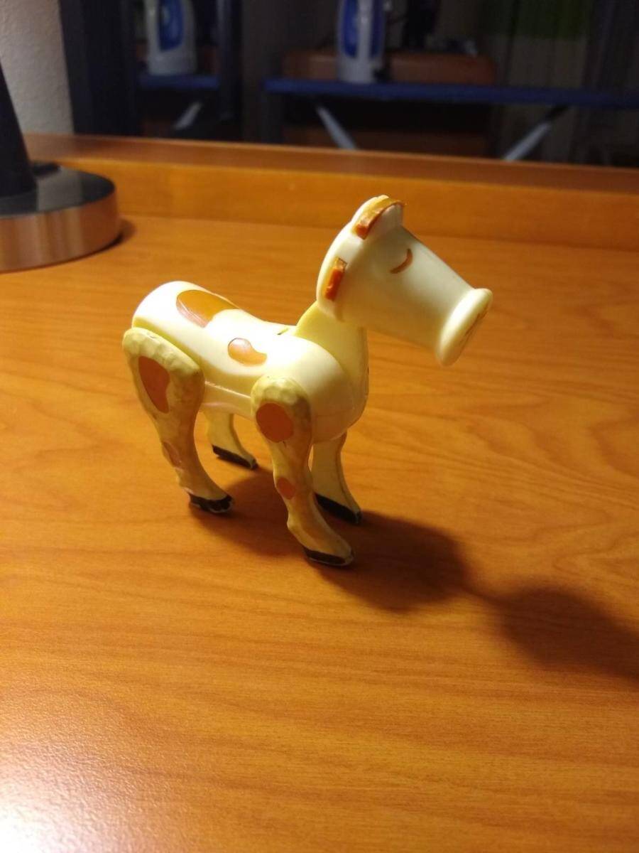 A toy cow on a wood desk