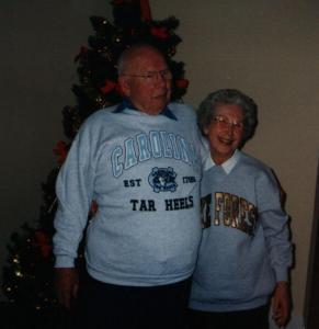 My grandmother and grandfather standing in front of a Christmas tree.